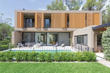 Fachada moderna con lamas de madera y piscina — proyecto Casa Bosque Chico, por Mazzinghi Sanchez, en Garin